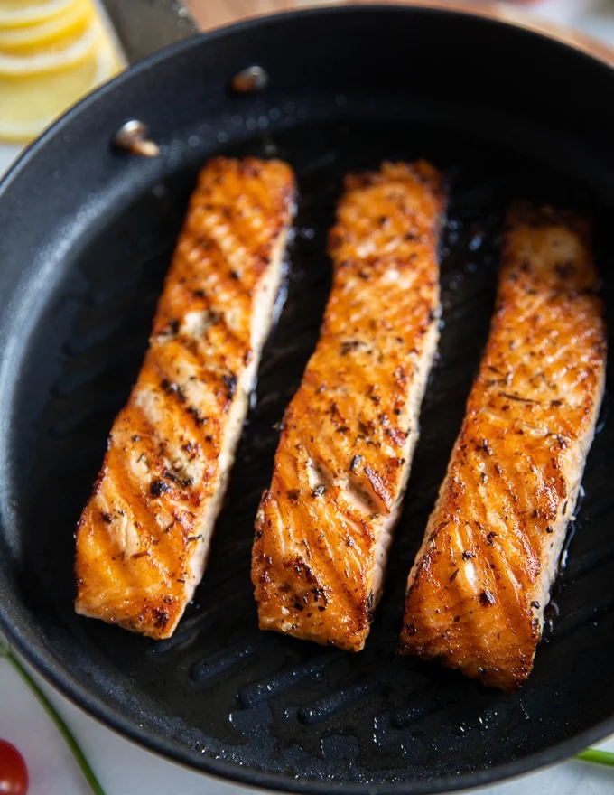 ready stove top grilled salmon in a stove top grill showing the texture and char on the salmon