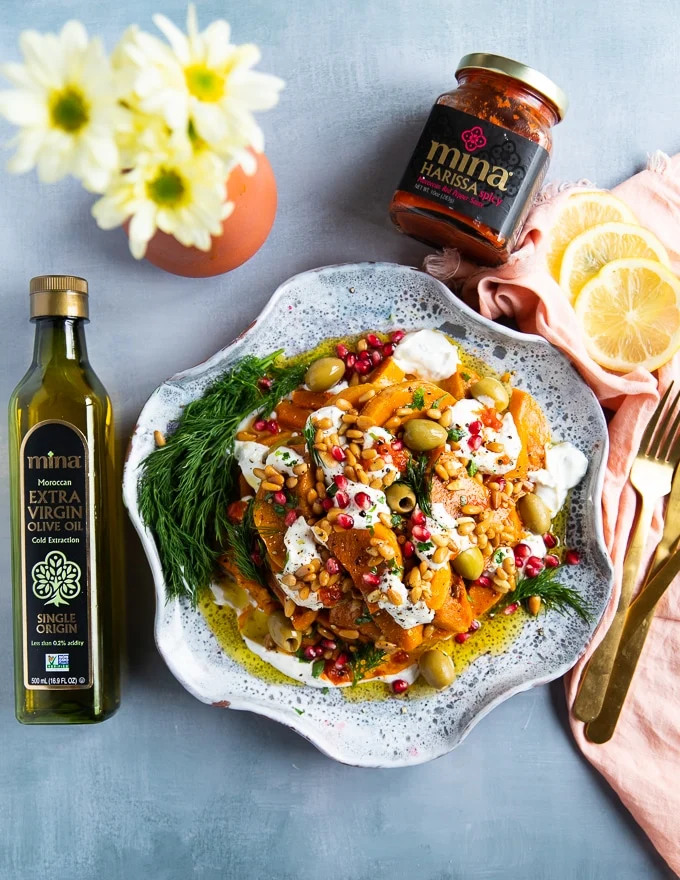 The plate of roasted honeynut squash surrounded by Mina Moroccan Olive Oil and Mina Harissa sauce