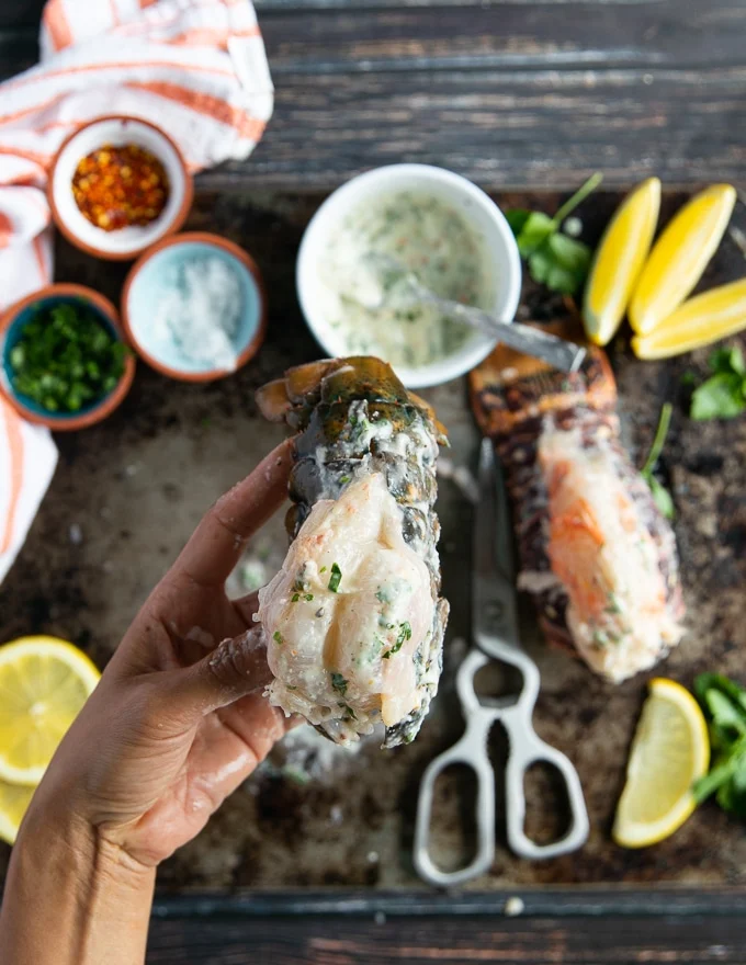 A lobster tail fully coated in the garic mixture and ready to be broiled