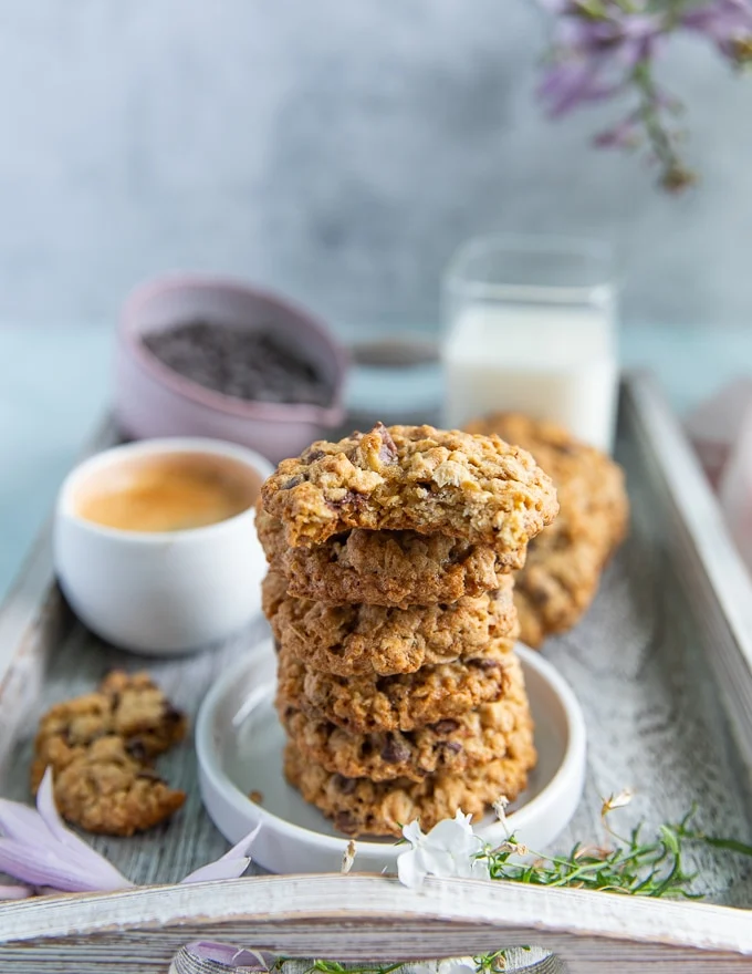 a stack of oatmeal cookies with a bitten cookie over the top showing the inside of the cookie