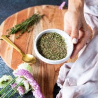A hand holding a plate of the dry spice blend ready to flavor the chicken breast