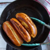 golden and toasted new england buns in a skillet ready for the lobster roll