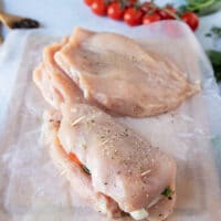 the chicken caprese is secured with toothpicks to seal in the filling