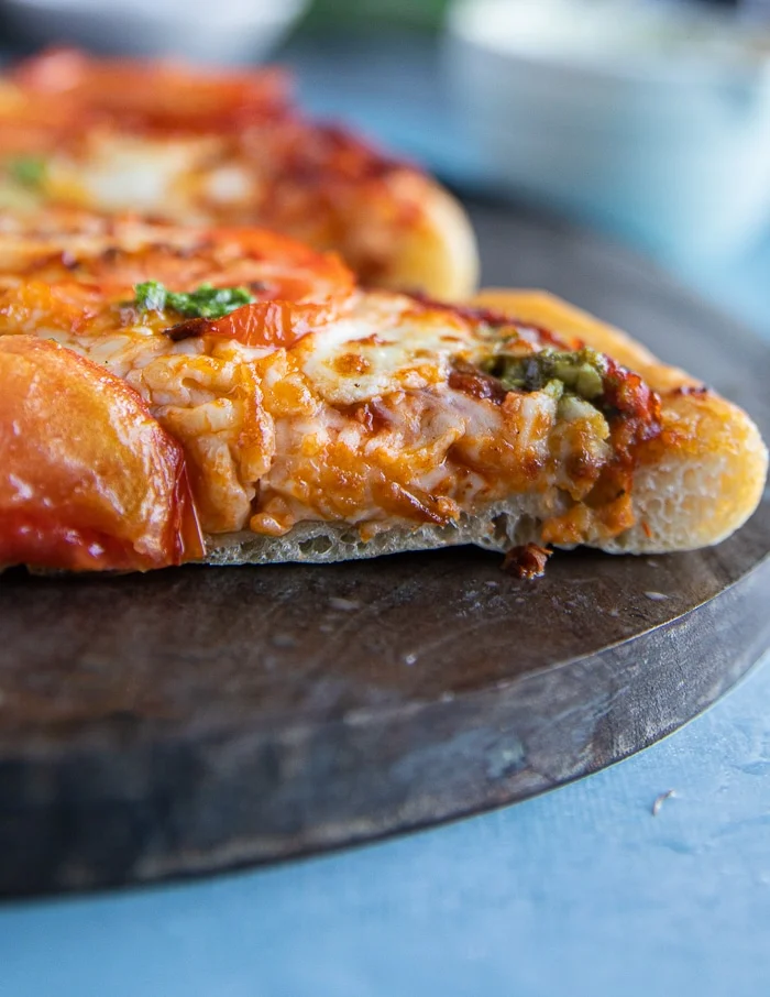 close up of a slice of pizza to show how the dough is perfectly cooked on the inside