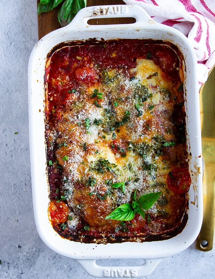 close up of veal parmesan baked in tomatoe sauce and topped with parmesan cheese, mozzarella and fresh basil
