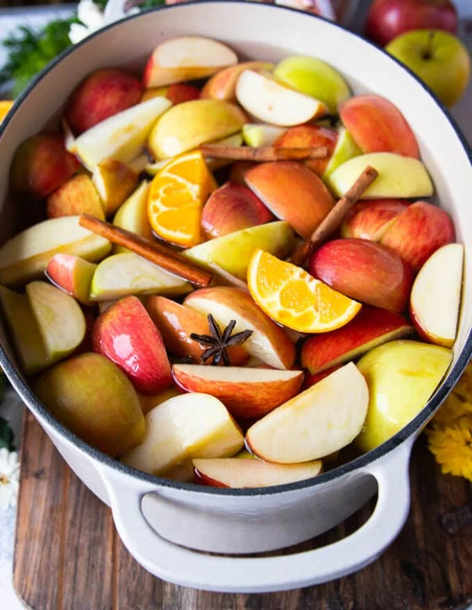 a large 7 quart pot filled with water and the apples, oranges and spices all added in