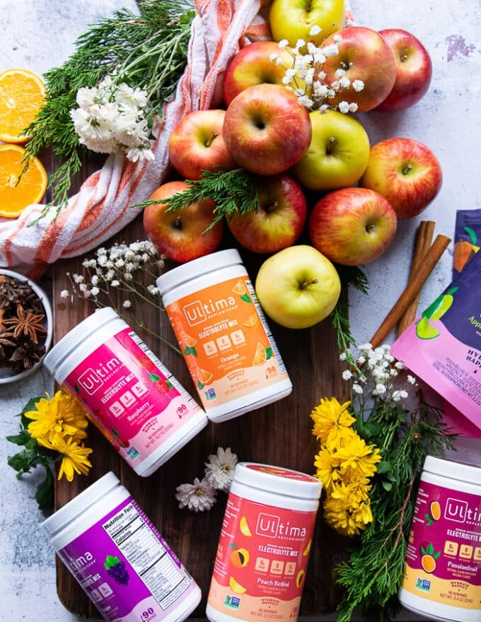 A collection of sweeteners with different flavors on a boad with the apples and spices
