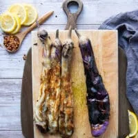Peeling the charred skin of the eggplant leaving in the soft cooked and smokey eggplant