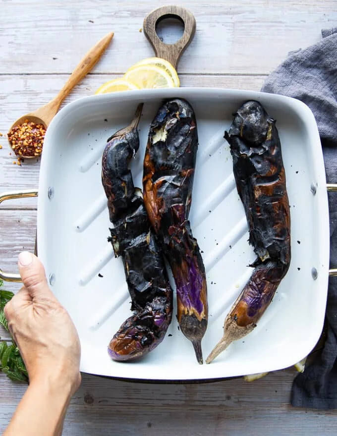 Fully charred eggplants on a plate