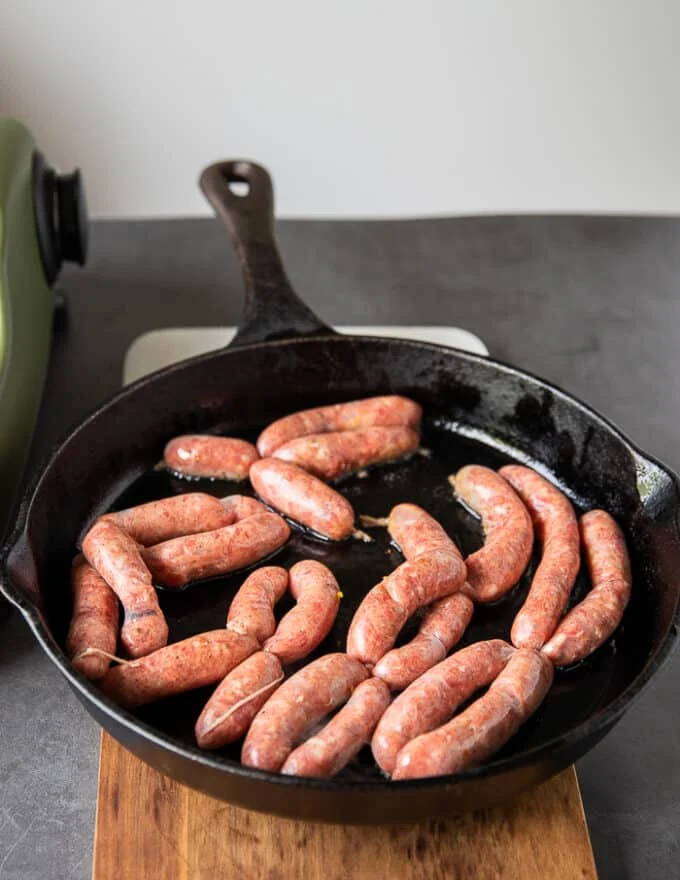 cooking sausage links in a skillet