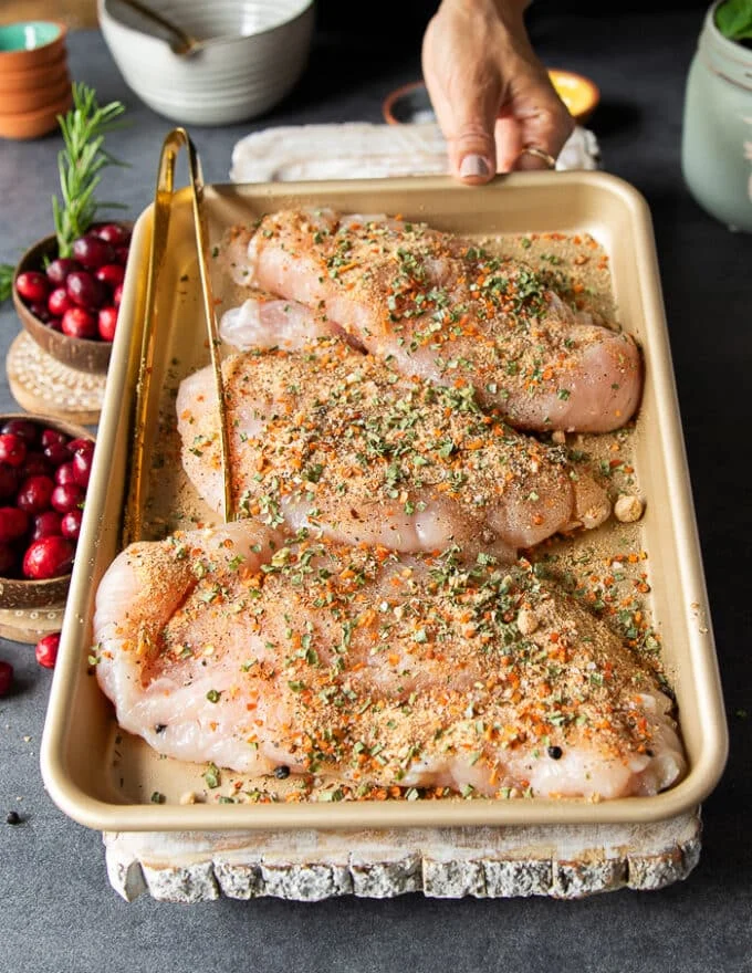 turkey tenderloins in a sheet pan seasoned with the dry seasoning spice mix