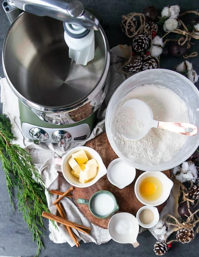 Ingredients for the cinnamon roll dough including flour, some soft butter, egg, yeast, sugar, salt, egg