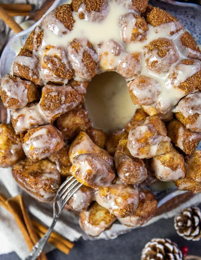 A fork breaking up the cinnamon roll monkey bread