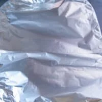 The leg of lamb covered with parchment and foil and ready to slow roast