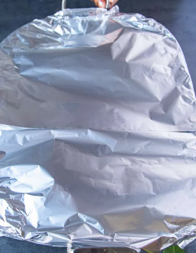 The leg of lamb covered with parchment and foil and ready to slow roast