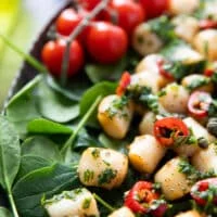 Cooked scallops in the air fryer served over a bed of spinach and drizzled with chimichurri sauce