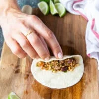 A hand placing the filling along the middle of the tortilla