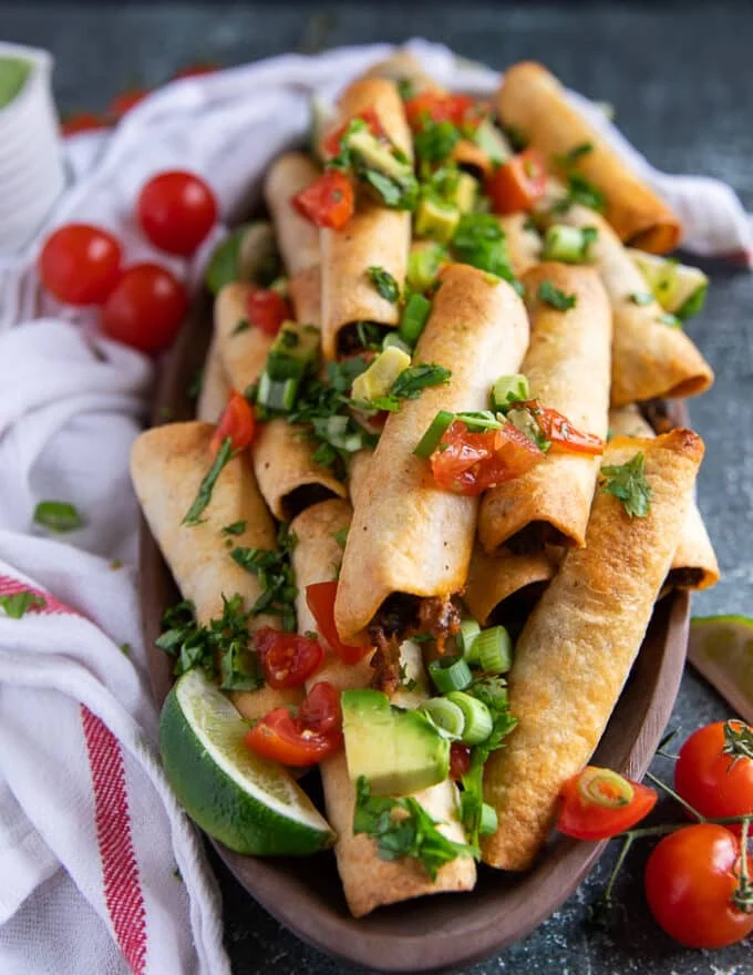close up of air fryer taquitos in a plate showing how crisp the texture is