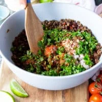 The first step to make taquitos is to prepare the filling, so a bowl with cooked beef has some salsa, cilantro, garlic and onions added to it