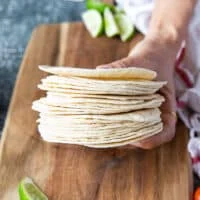 A hand holding the tortillas showing close up of the tortillas size and thickness