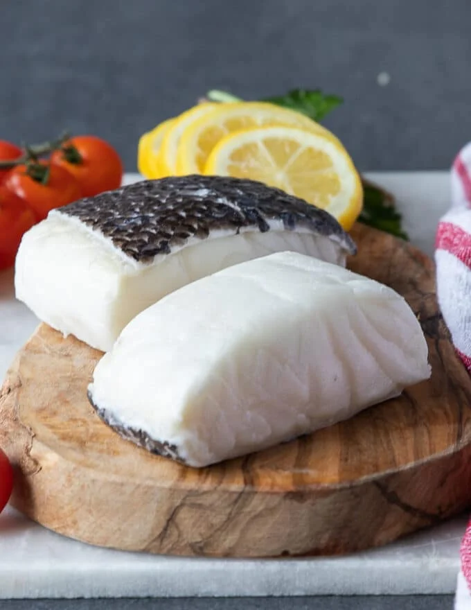 Chilean sea bass fillets on a wooden board showing the fillets
