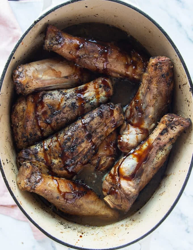 lamb shanks added back to the pan and ready to be braised with the sauce