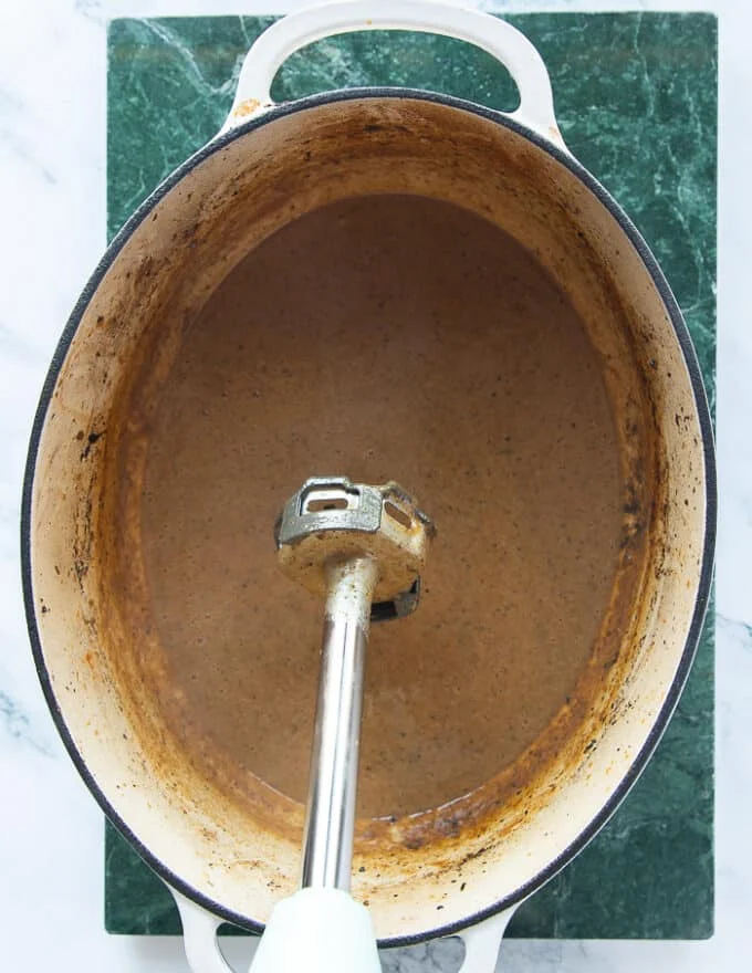 An immersion blender used to make the braising liquid turn into a smooth soft gravy