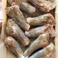 Seasoned lamb shanks on a tray ready to braise