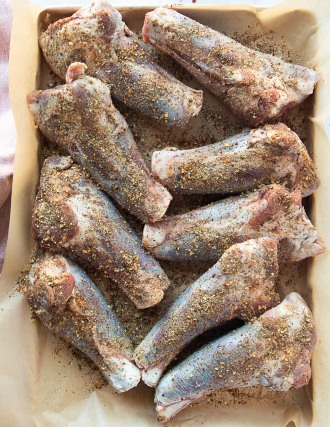 Seasoned lamb shanks on a tray ready to braise