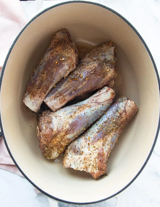 Lamb shanks in a heavy duty dutch oven pan for searing