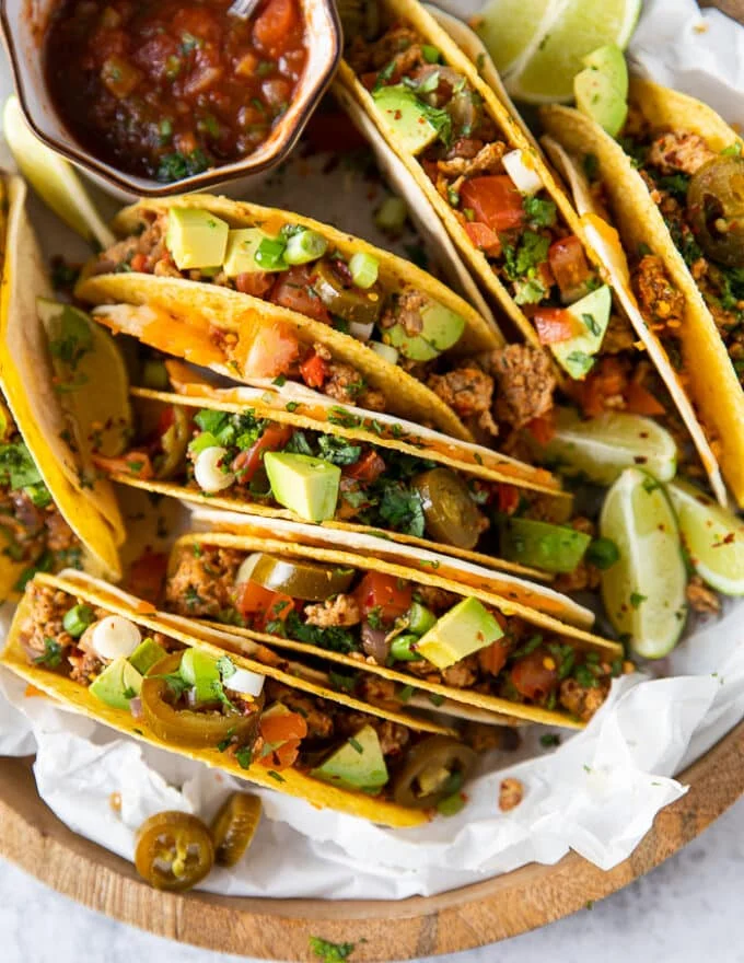 Close up of each assembled ground chicken taco showing different toppings for each one