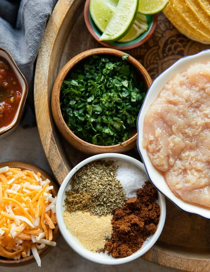 homemade taco seasoning for the ground chicken in small bowls including onion powder, garlic powder, chilli powder, oregano and cumin
