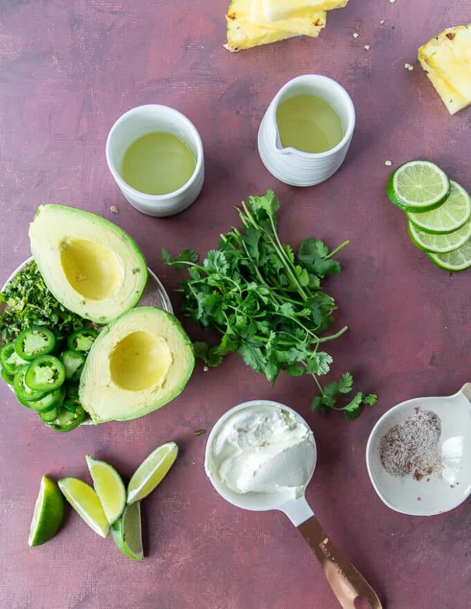 Avocado Crema ingredients including avocados, sour cream, lime juice, cilantro, salt, jalapeños