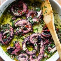 The cooked octopus added to the marinade and tossed to coat