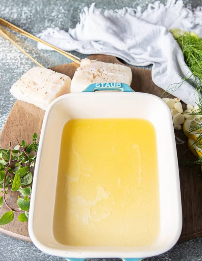 An oven safe dish with lots of melted butter ready to for the halibut recipe