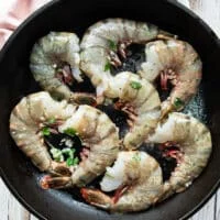 shrimp added in a single layer in a hot skillet to cook
