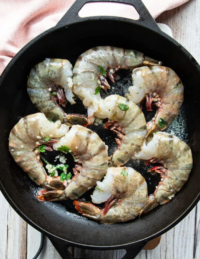 shrimp added in a single layer in a hot skillet to cook