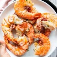Cooked shrimp on a clean plate removed from the pan so the pan is used to make the scampi sauce