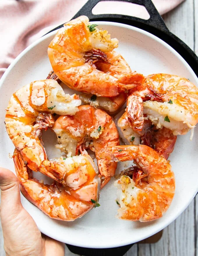 Cooked shrimp on a clean plate removed from the pan so the pan is used to make the scampi sauce