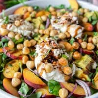 close up of the final dressed peach burrata salad showing the peaches and creamy burrata with a balsamic glaze