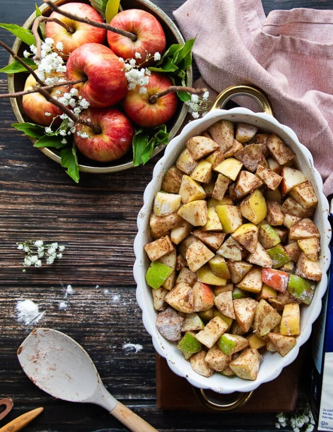 The apple mixture ready and tossed with cinnamon, sugar and flour in the baking dish ready for the topping