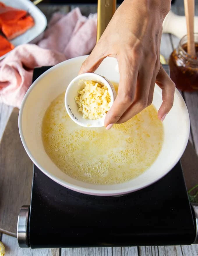 making the honey glaze showing a skillet of butter melting and garlic being added