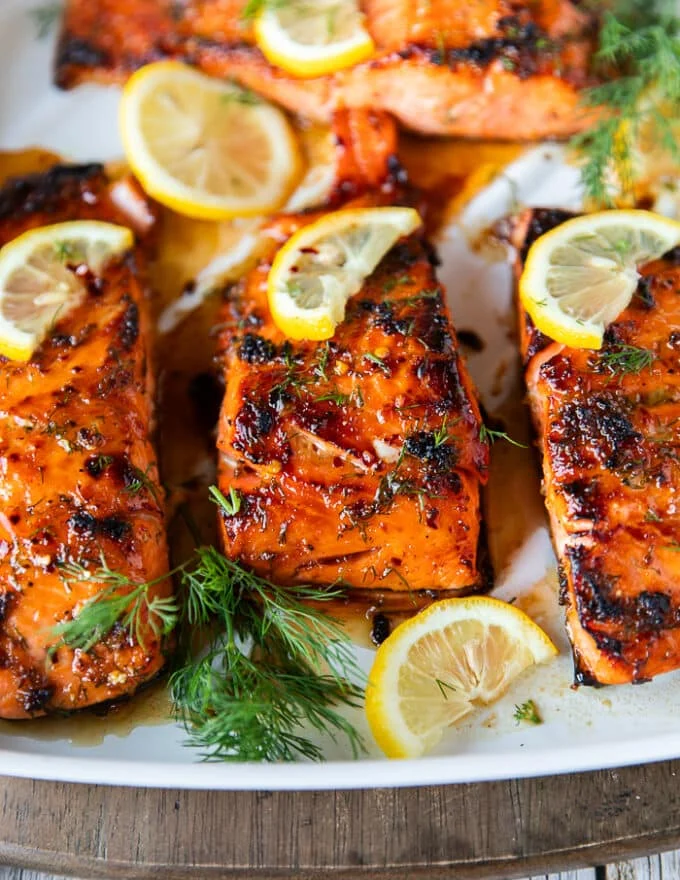 close up of a honey baked salmon showing the deep golden crust and sweet glaze over the salmon