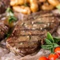 Close up of a ribeye steak cooked perfectly on the grill with grill mark and some melted butter on top