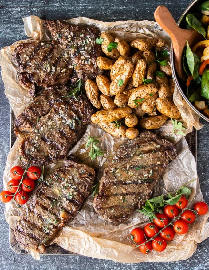 Butter dolloped over the cooked ribeye steak while still hot and butter is melting
