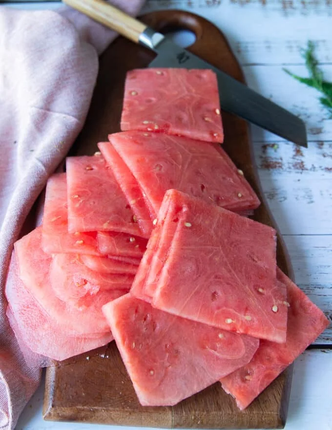 Finished slices of a block of watermelon on a wooden board