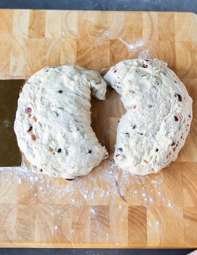 Fougasse dough divided into two halves on a wooden board