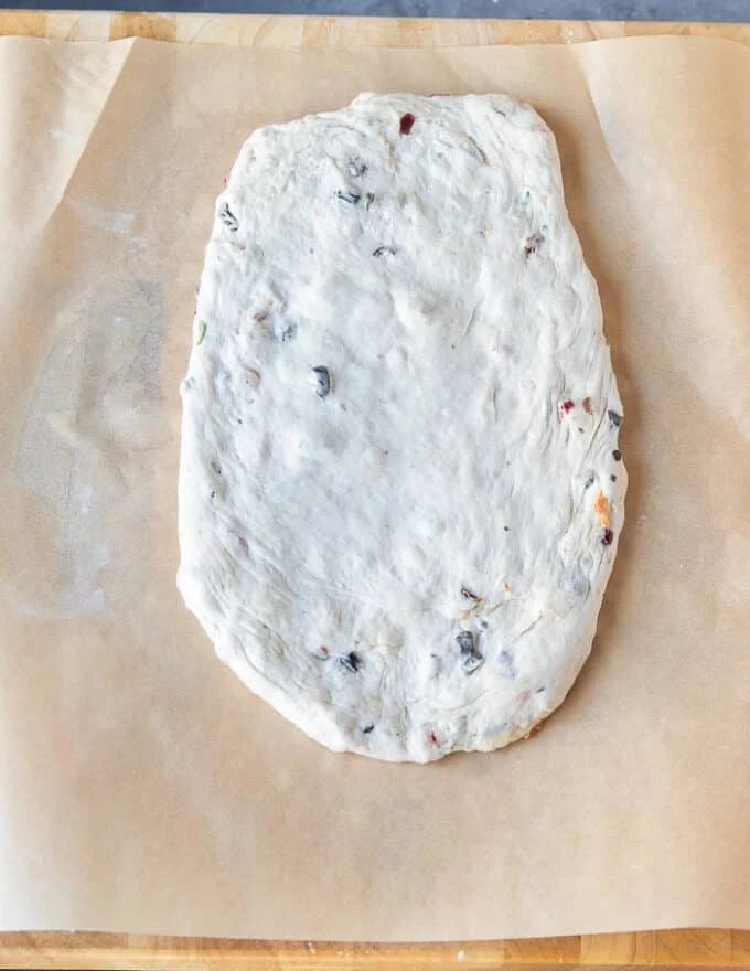 The fougasse dough flattened or rolled into an oval shape first