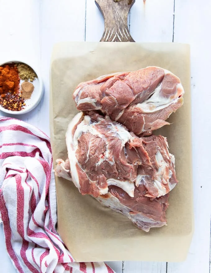 A leg of lamb, deboned on a parchment paper showing the cut, the marble and the piece of meat