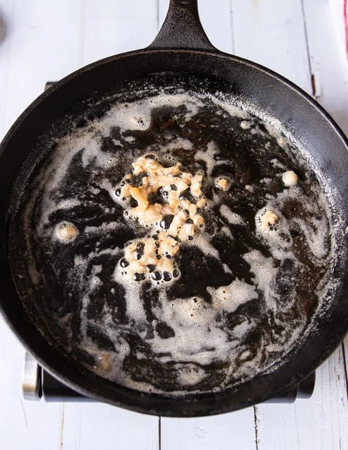 Lamb fat and butter melting a large cast iron skillet